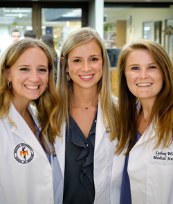 Three students in white coats