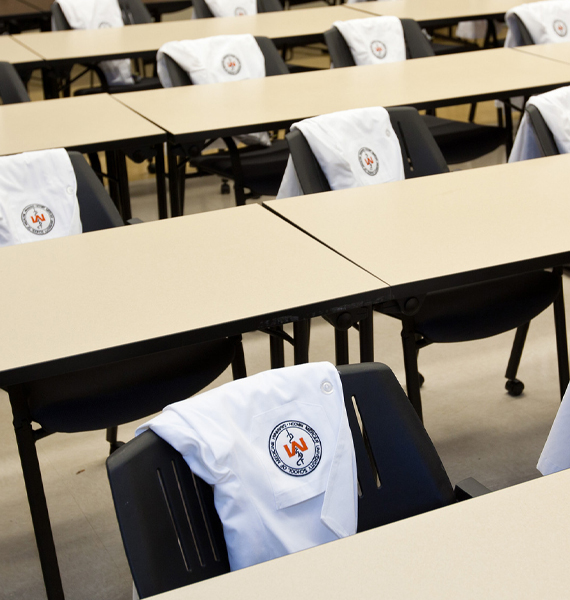 A room with white coats draped over chairs