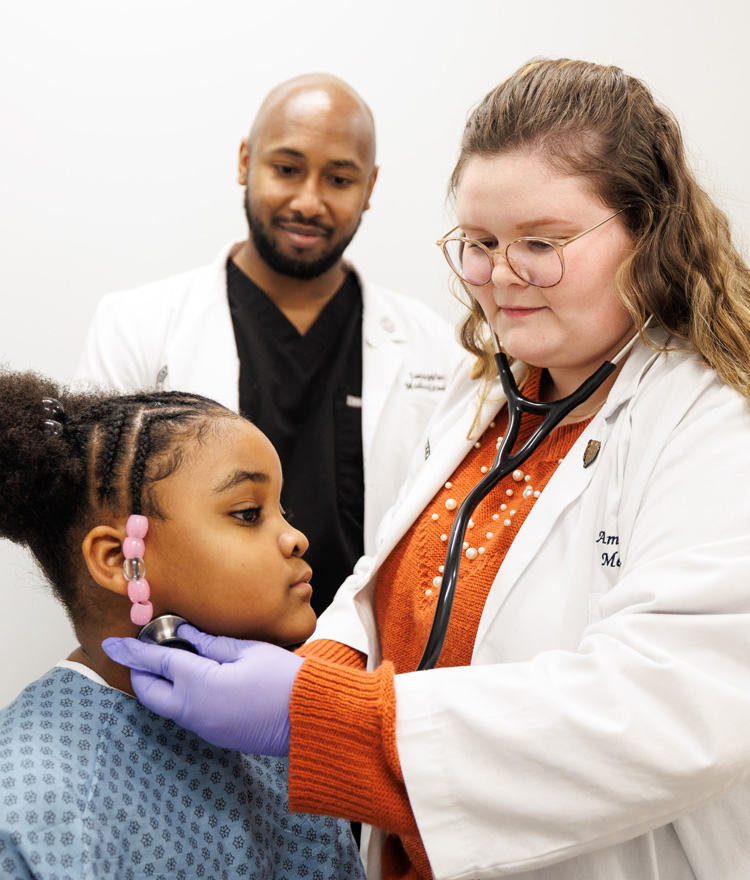 two medical students check young girls pulse