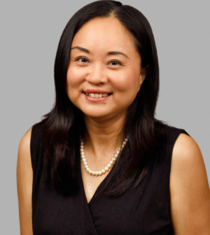 professional headshot of a smiling woman with black hair and grey background