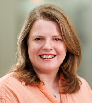 Professional headshot of smiling woman with blond hair.