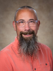 Michael Kramer in red shirt with glasses on.