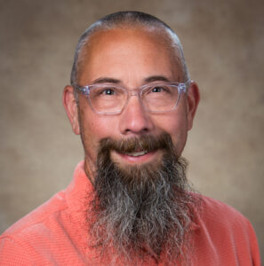 Michael Kramer in red shirt with glasses on.