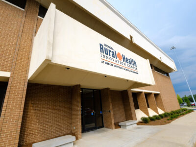 Outside Georgia Rural Health Innovation Center building with sign.
