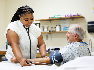 Young female checks blood pressure of older male
