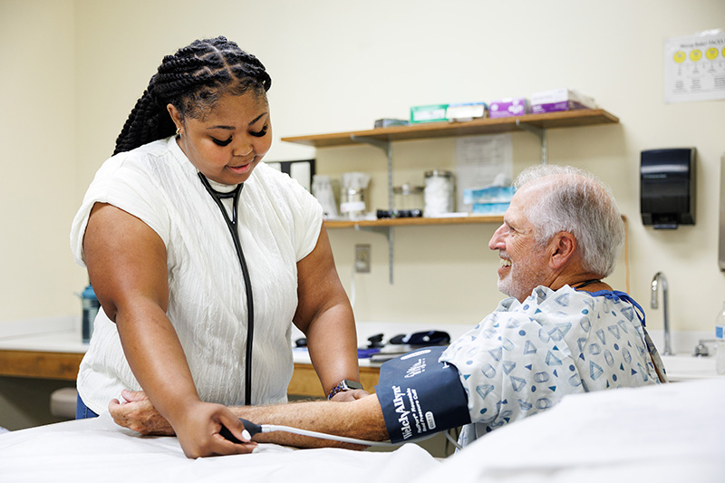 Young female checks blood pressure of older male