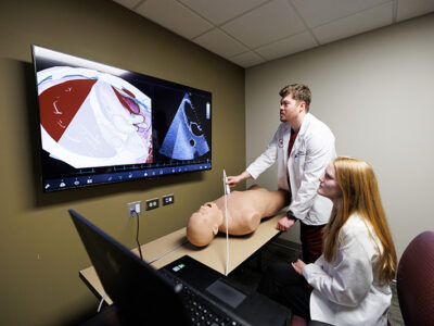 One student scans manikin while other female students looks at monitor