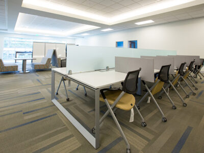 Learning space with tables, chairs, and dividers for privacy.