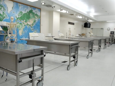 Room with big map on white walls and several metal beds
