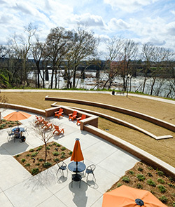 Tables, orange umbrellas with river in the background