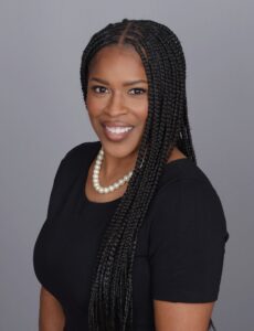 Woman wearing black blouse and a pearl necklace.