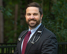 Man outside in dark suit and red tie