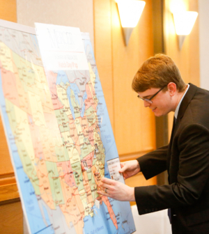 Dr. Russ Hopper pins an image to a map, indicating his residency destination in Columbus, Georgia.