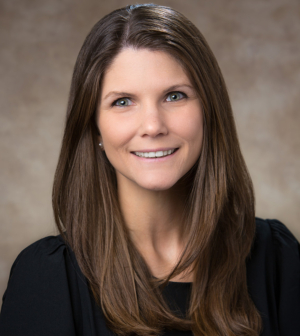 Woman with brown hair in black shirt smiles.