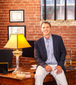 Dr. Allen Lee smiling in his office