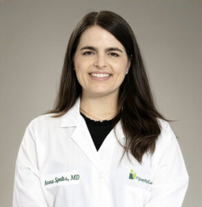 Dr. Anna Spelts smiling at the camera while wearing her white coat.