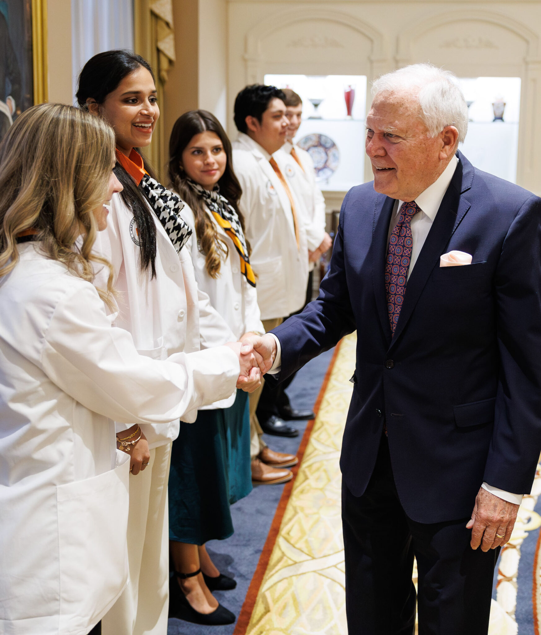 Former Governor Nathan Deal shaking hands with scholarship recipients at a pinning ceremony.